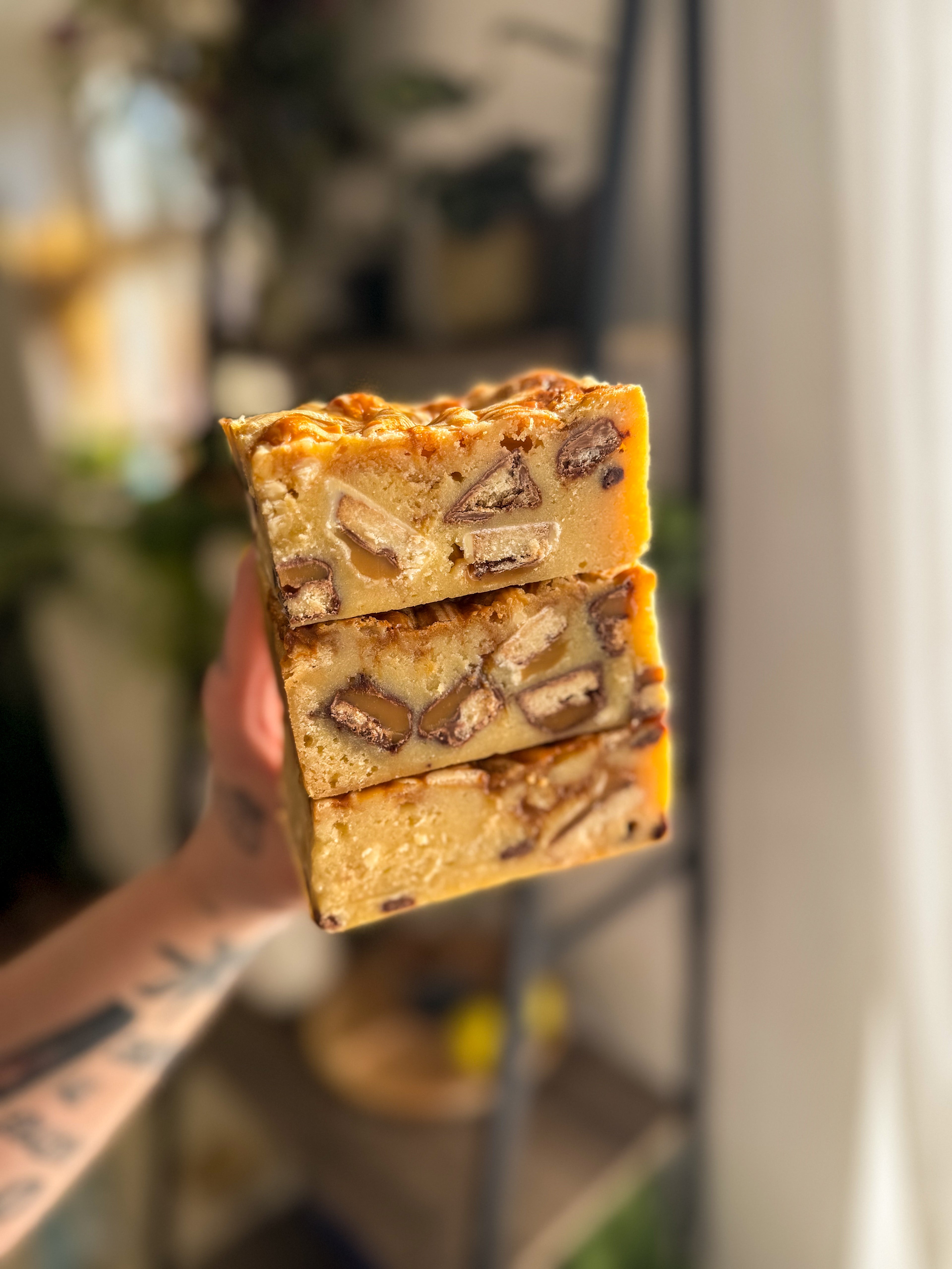 Thick milk and white chocolate Twix blondie with a fudgy centre, caramel drizzle and chunks of Twix throughout