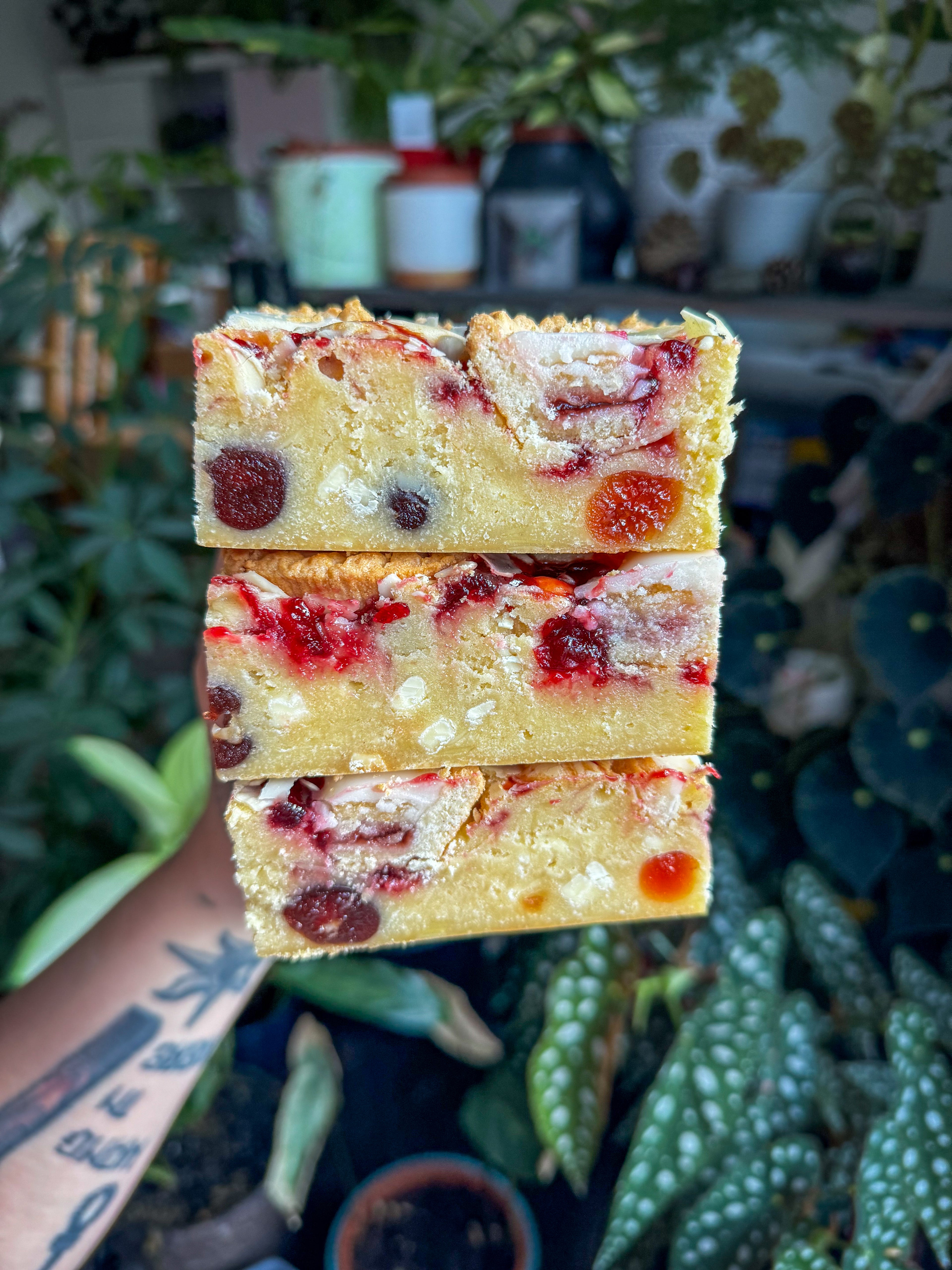 Thick Bakewell blondie with cherry jam swirled through the fudgy blondie and pieces of glacé cherry throughout